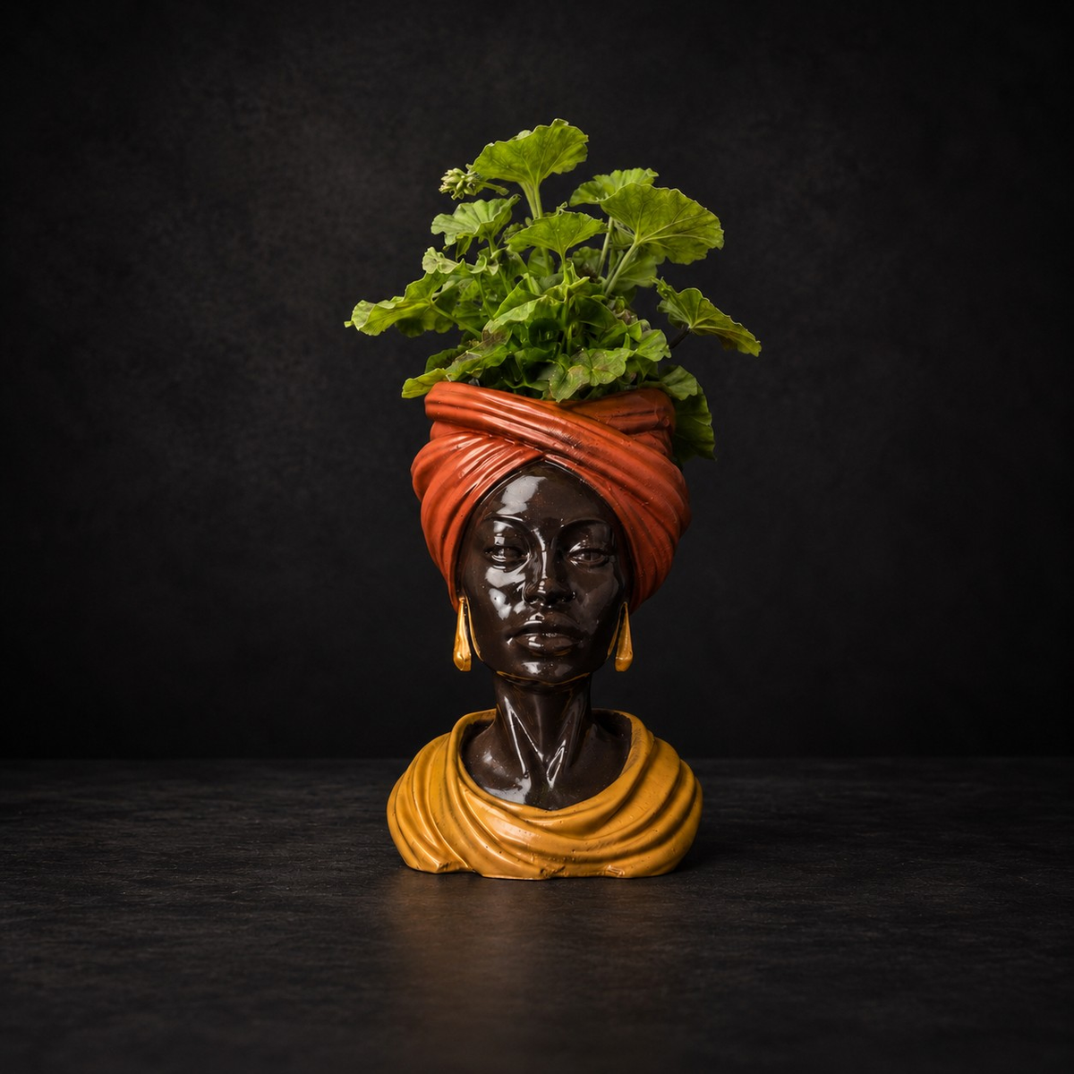 Golden Hour cast stone head planter with green plant on moody black background