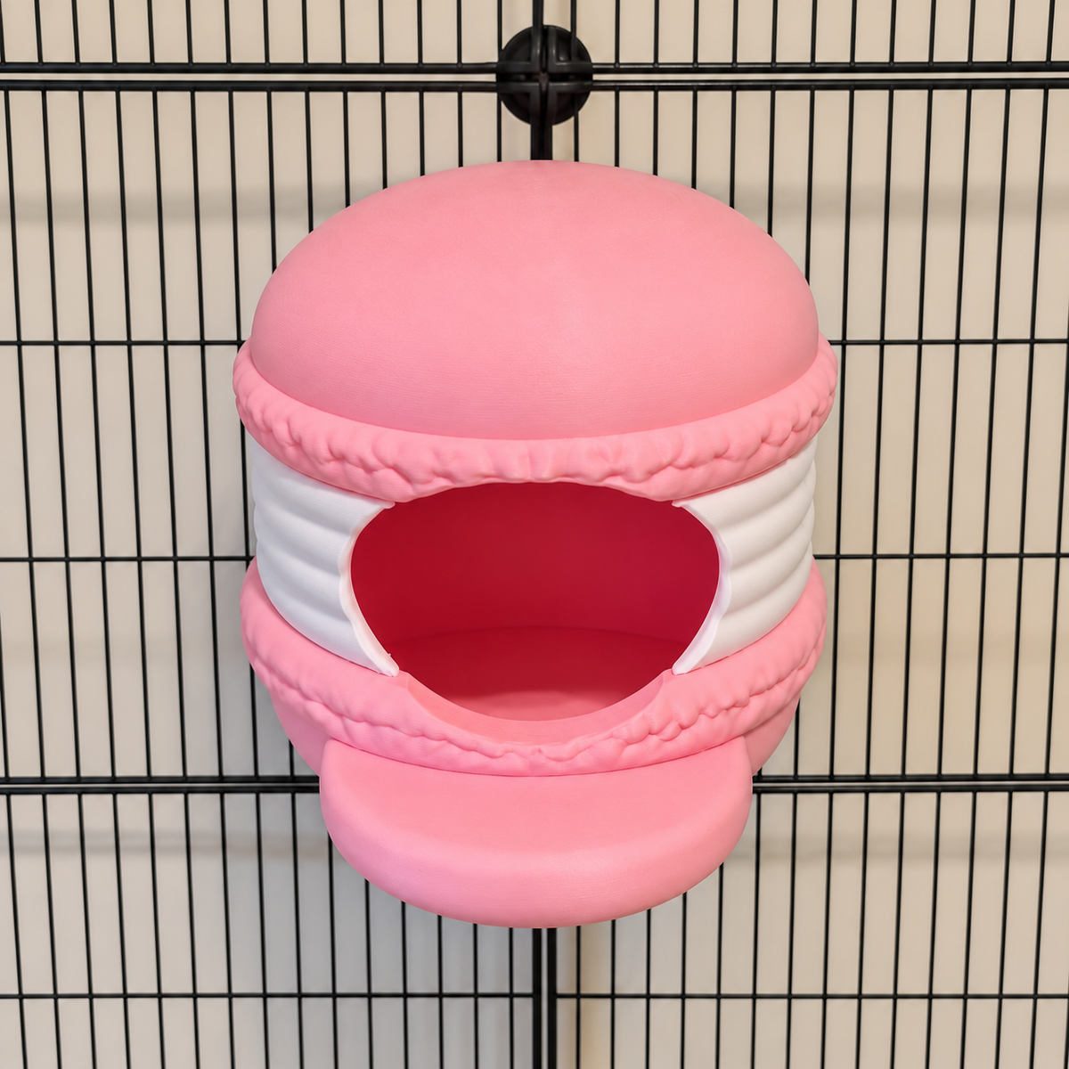 Elevated view of a pink and white macaron hide mounted on cage bars.
