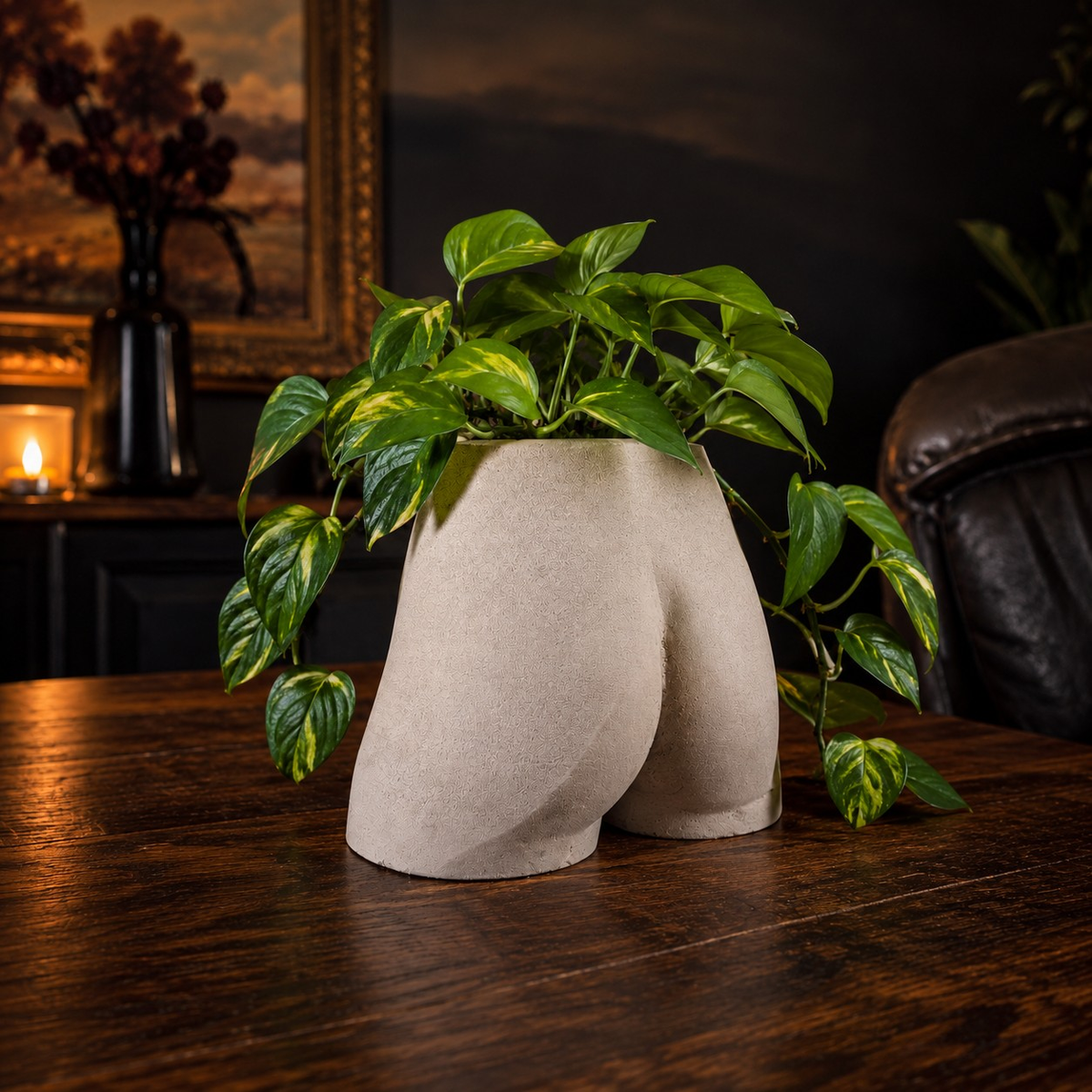 Side lifestyle view of Cheeky Bum cast stone planter in a warm dark room