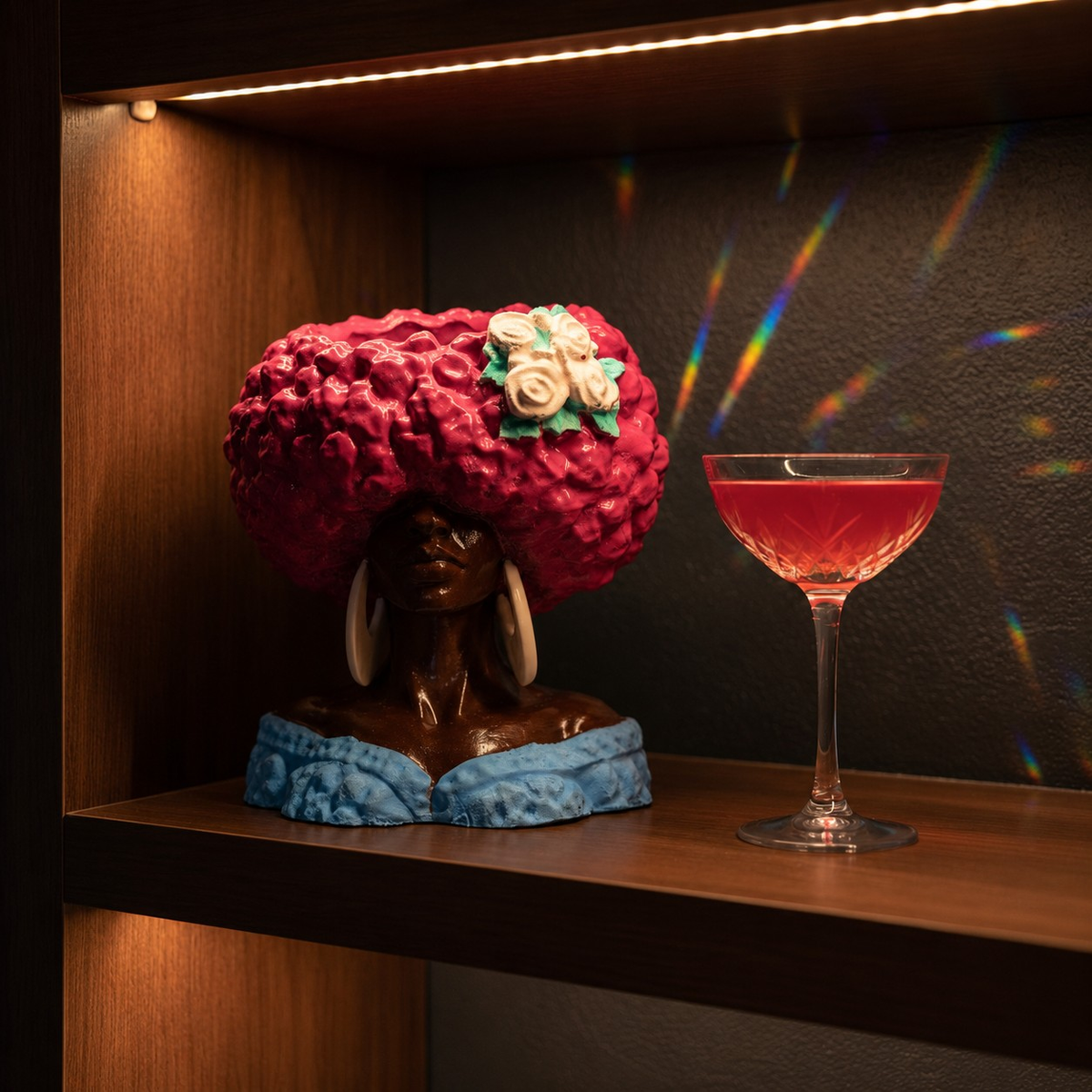 Girl Juice head planter styled on a shelf beside a pink cocktail glass