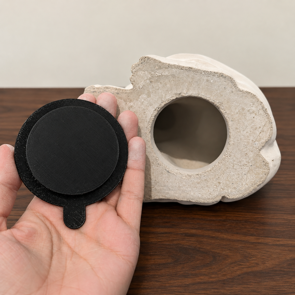 Shared closure example showing a black plug beside an urn base opening