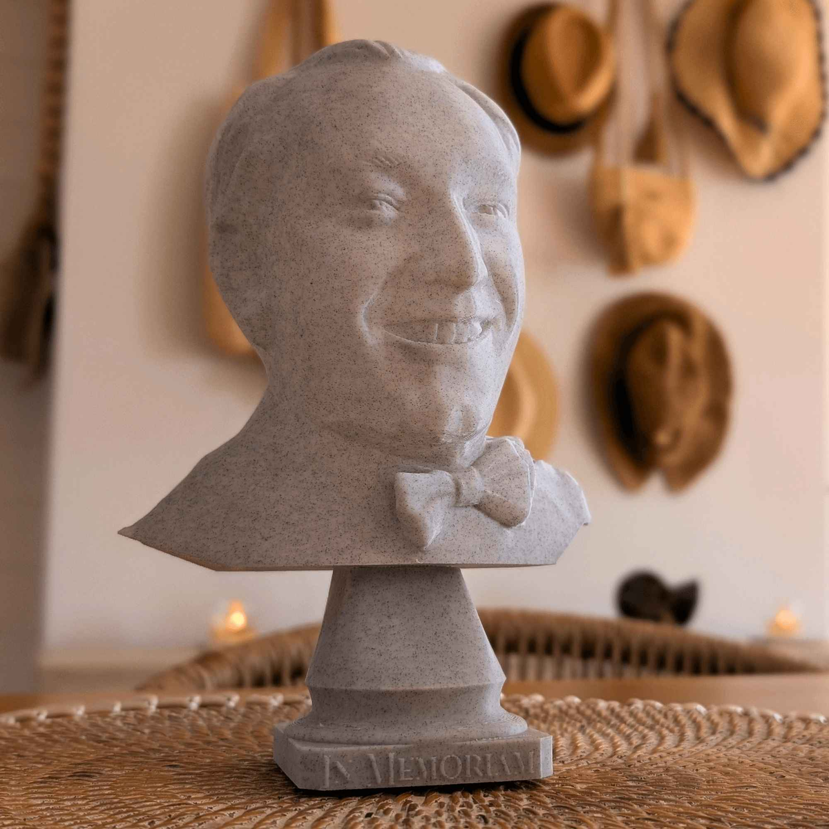 Grey bow-tie portrait bust with engraved base displayed in a home