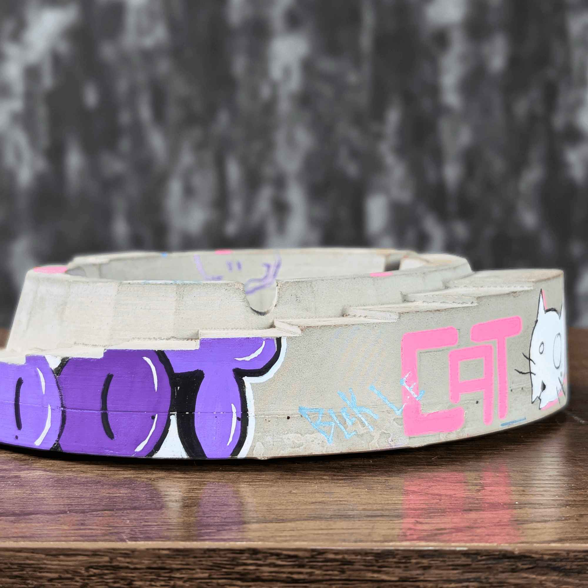 Side view of graffiti ashtray with CAT text and white cat artwork