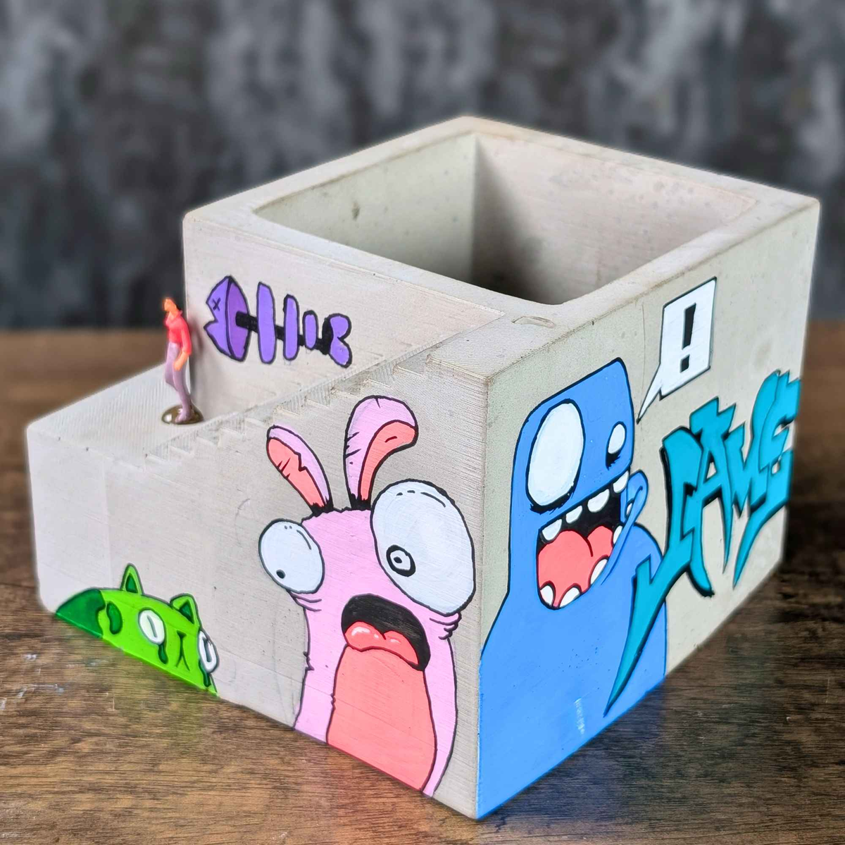 Empty graffiti building planter showing the open planting chamber and rabbit mural