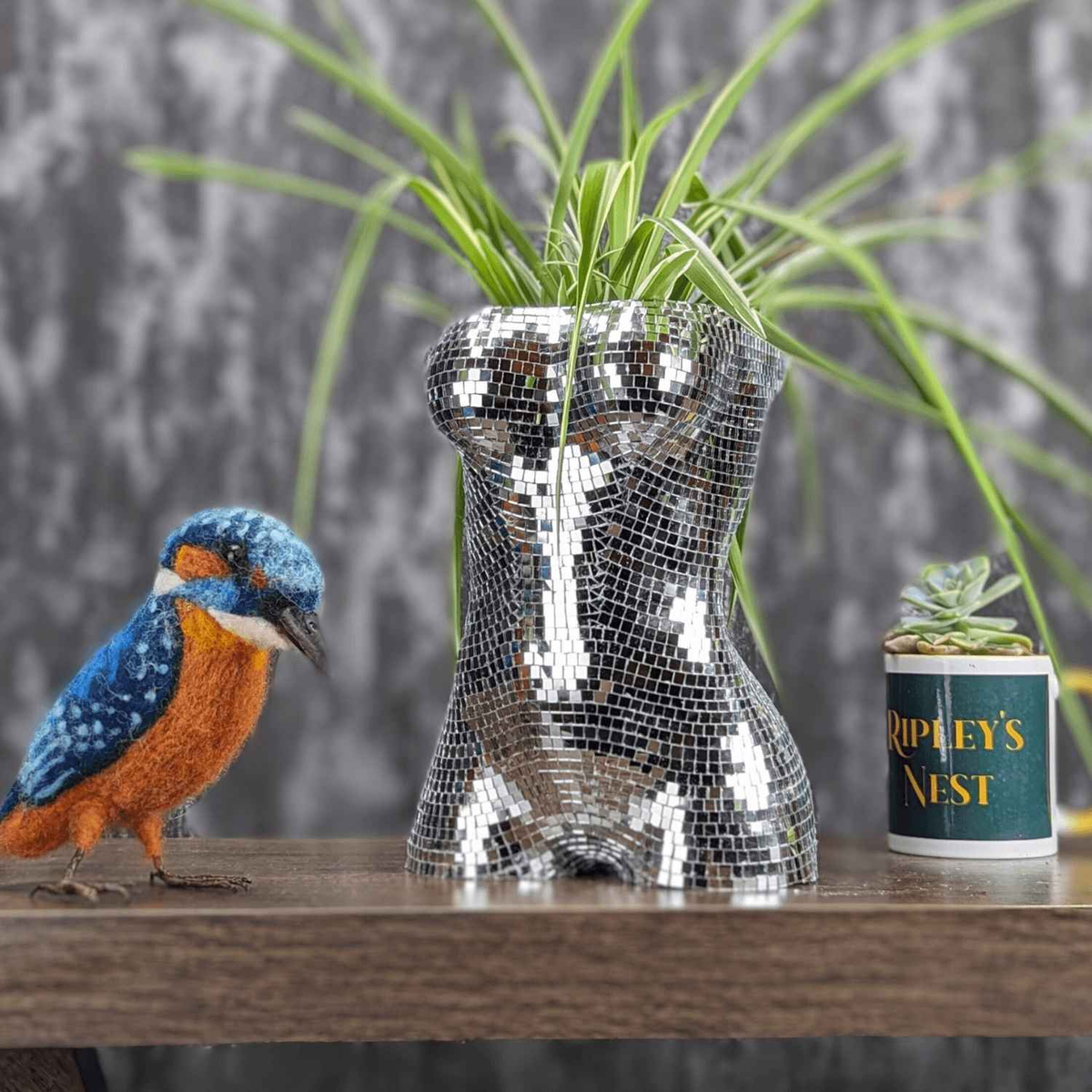 Mirror torso planter with houseplant, blue bird ornament and gold canister