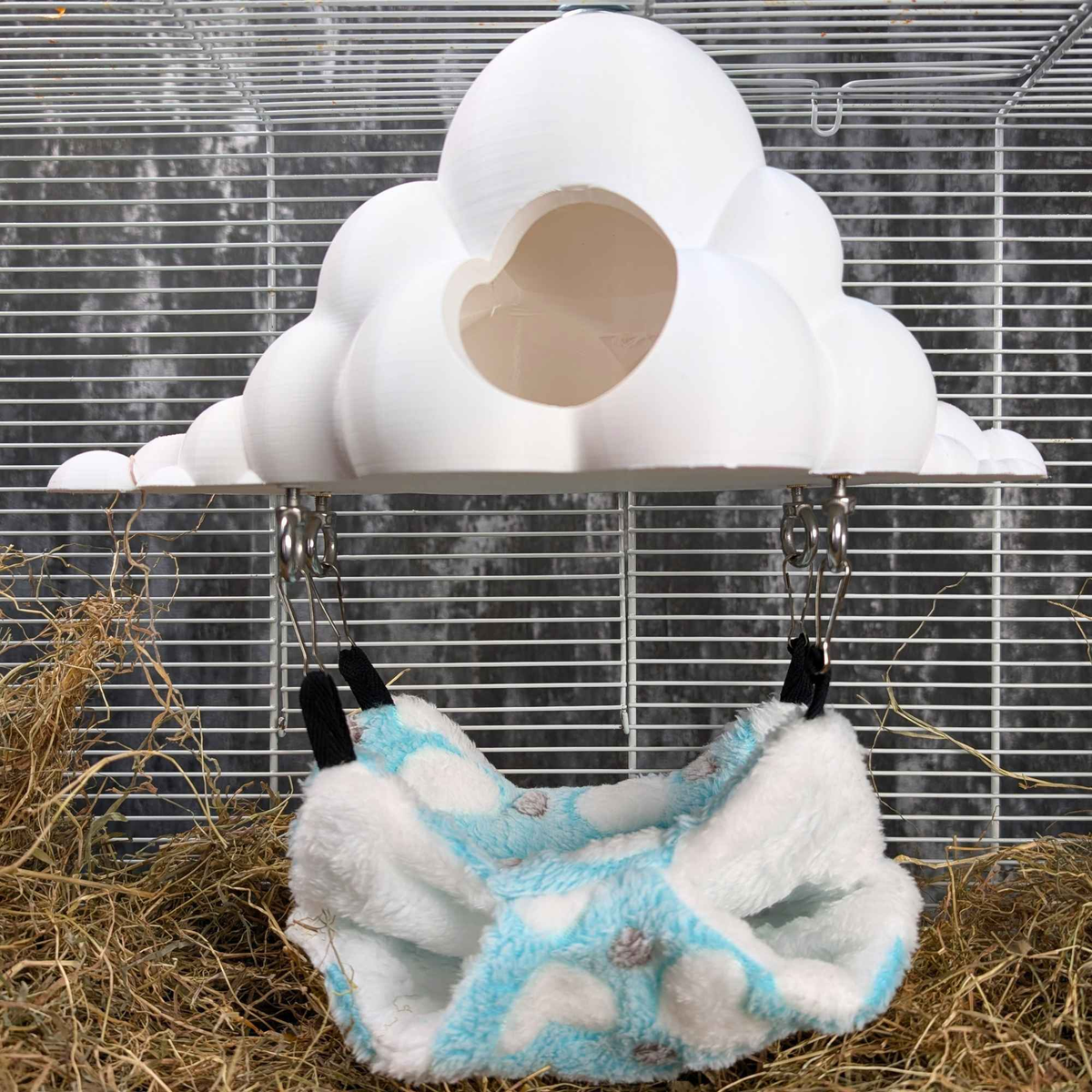 Empty cloud hide and blue hammock mounted together in a cage