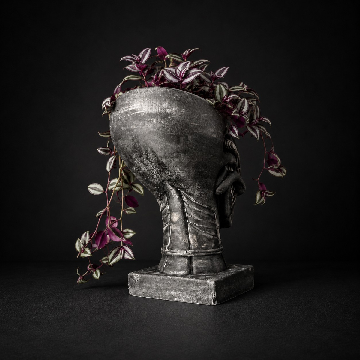 Rear view of Xenophyte cast stone head planter with trailing plant