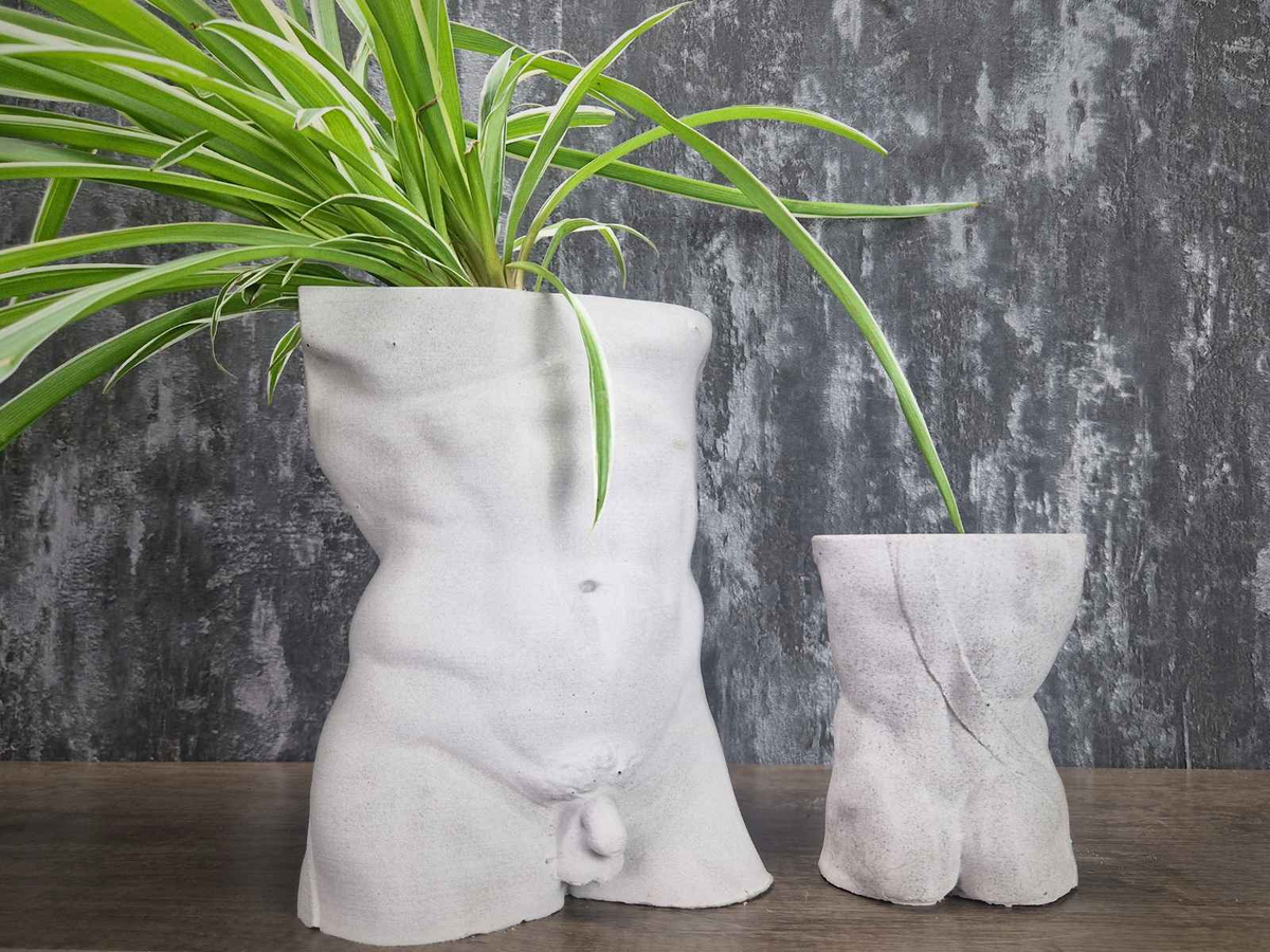 Planted Greek god male torso planter beside a smaller unplanted size