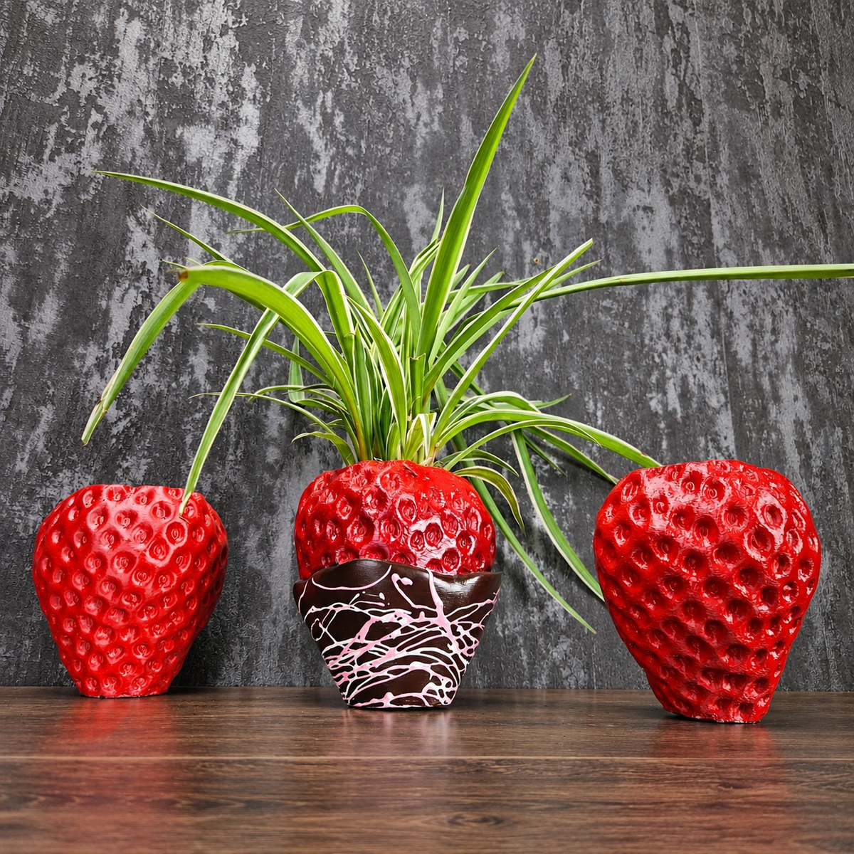 Two red strawberry planters and a planted chocolate-dipped strawberry planter