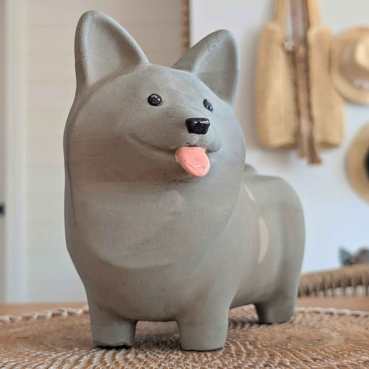 Corgi Garden Ornament: grey corgi with tongue out beside woven wall decor