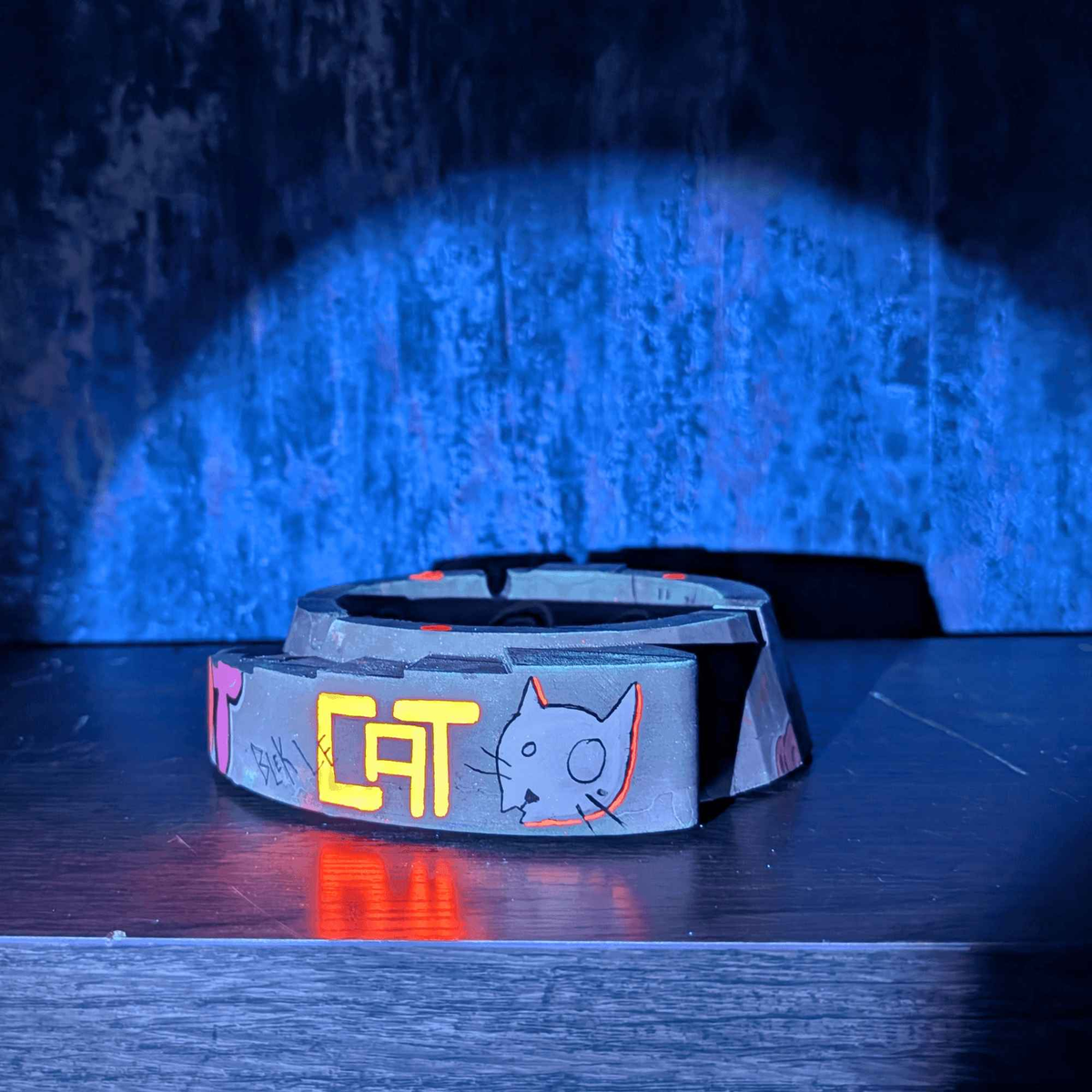 Custom graffiti ashtray photographed under blue and purple lighting