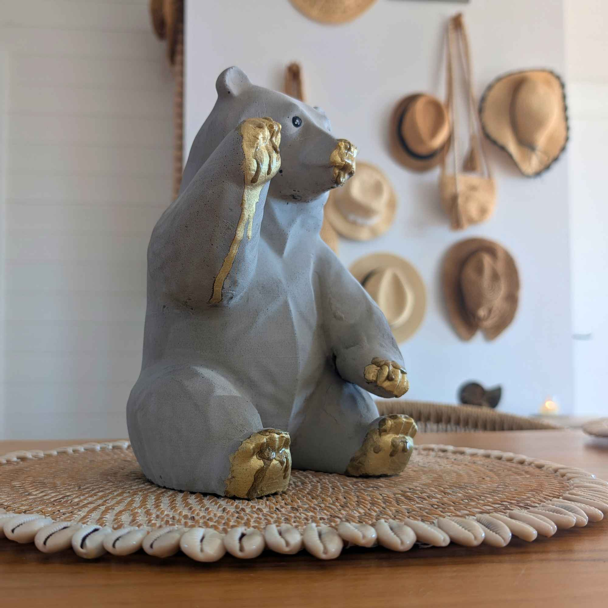 Honey bear garden ornament angled in a home setting with woven wall decor