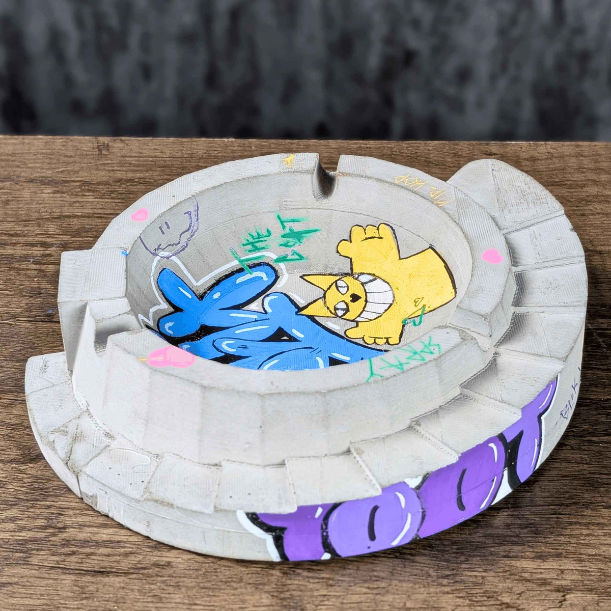 Angled top view of custom graffiti ashtray on a wooden table