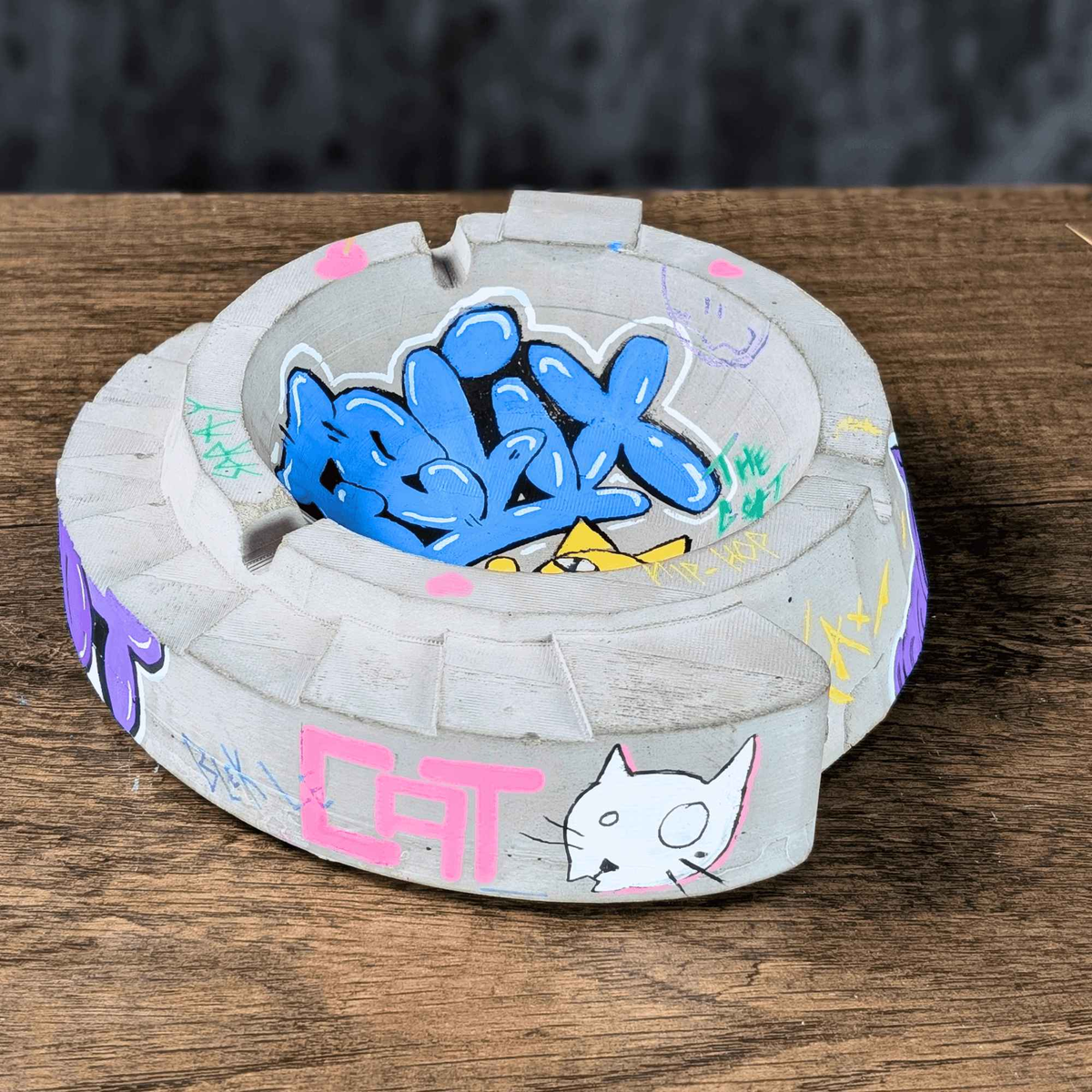 Angled front view of custom graffiti ashtray with CAT lettering