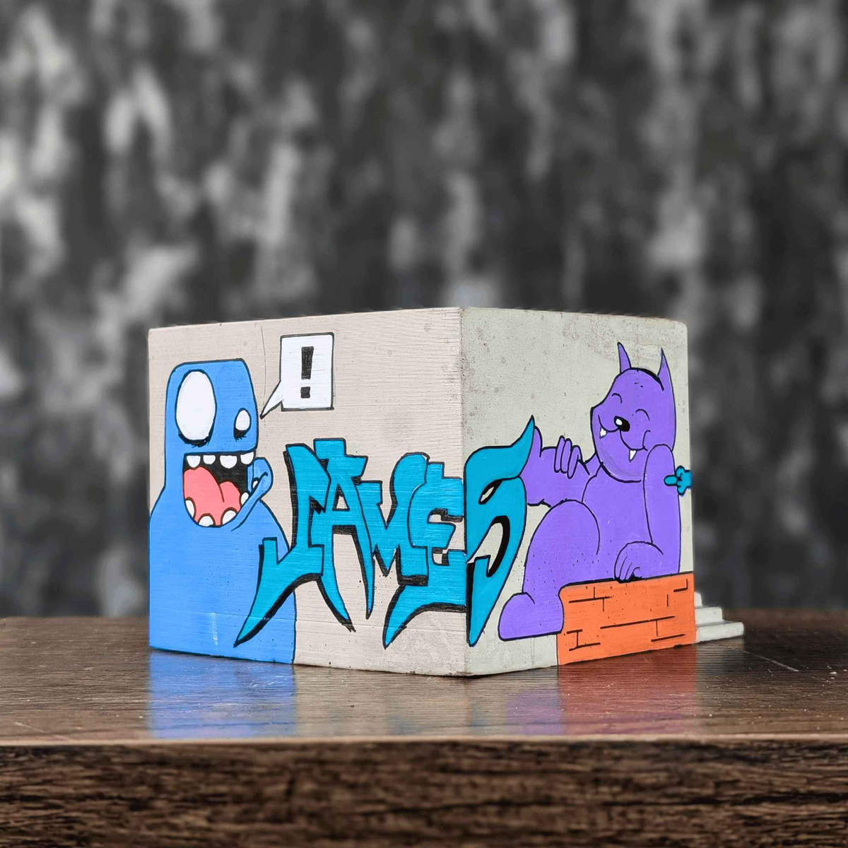 Front view of graffiti building planter with blue lettering and purple cat mural