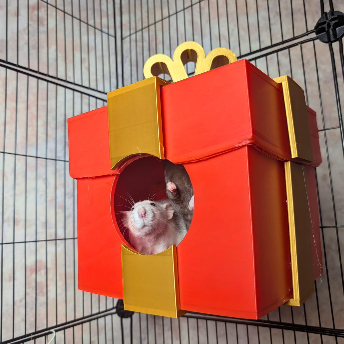 Red and gold wall-mounted present rat hide with two rats inside