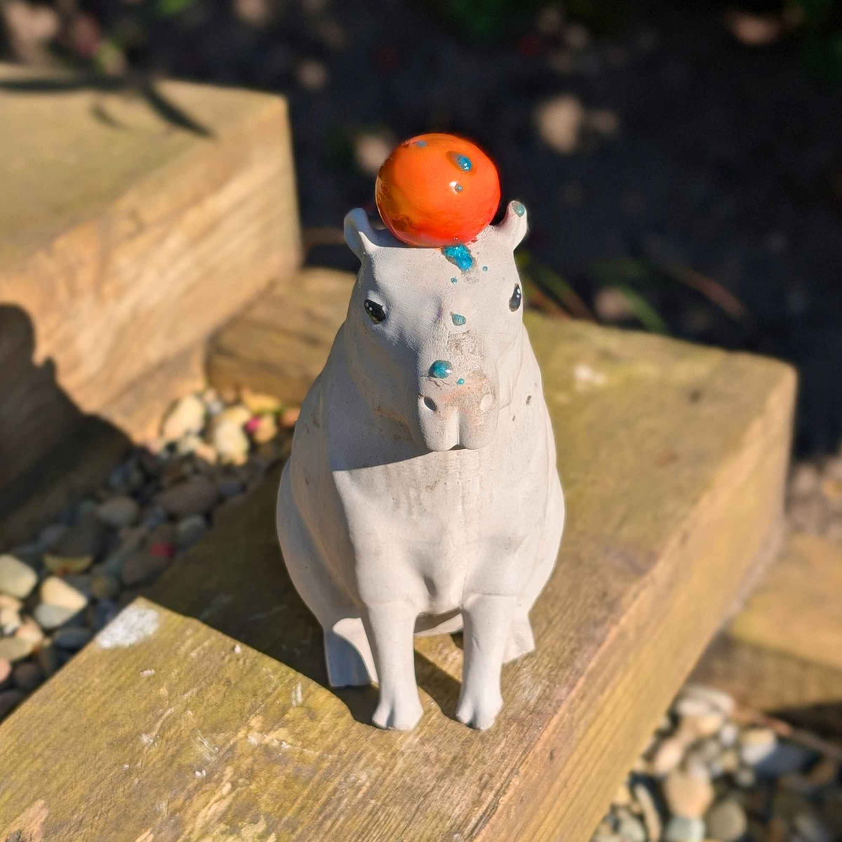 High-angle view of capybara ornament balancing an orange outdoors