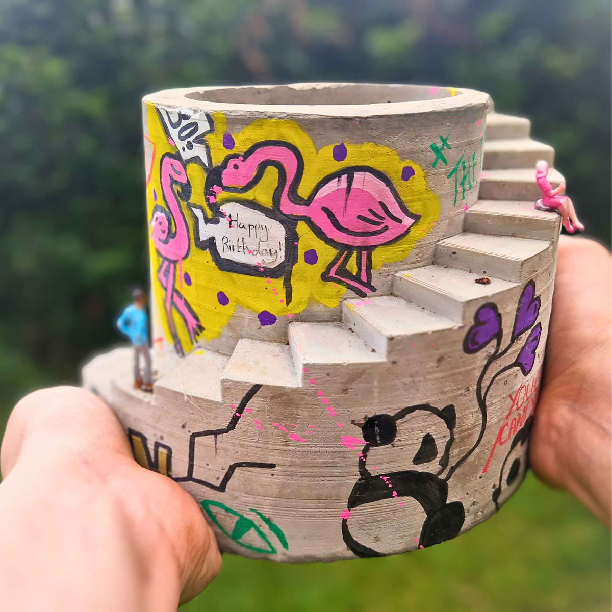 Custom graffiti stairwell planter held in one hand