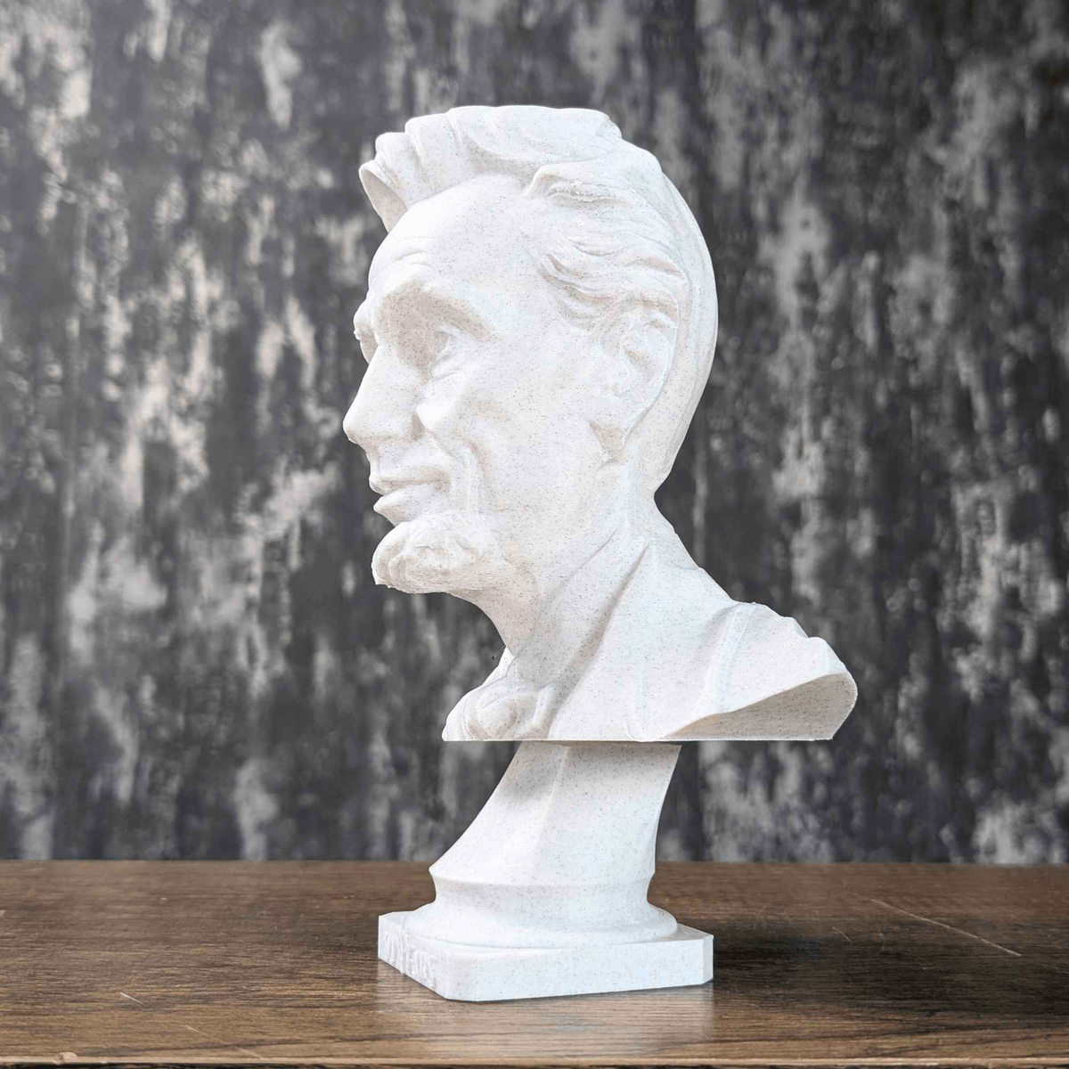 White Abraham Lincoln portrait bust shown in side profile on its pedestal