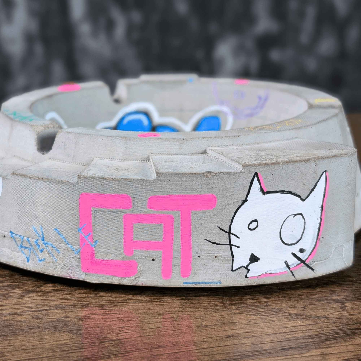 Front side of custom ashtray with CAT lettering and white cat drawing