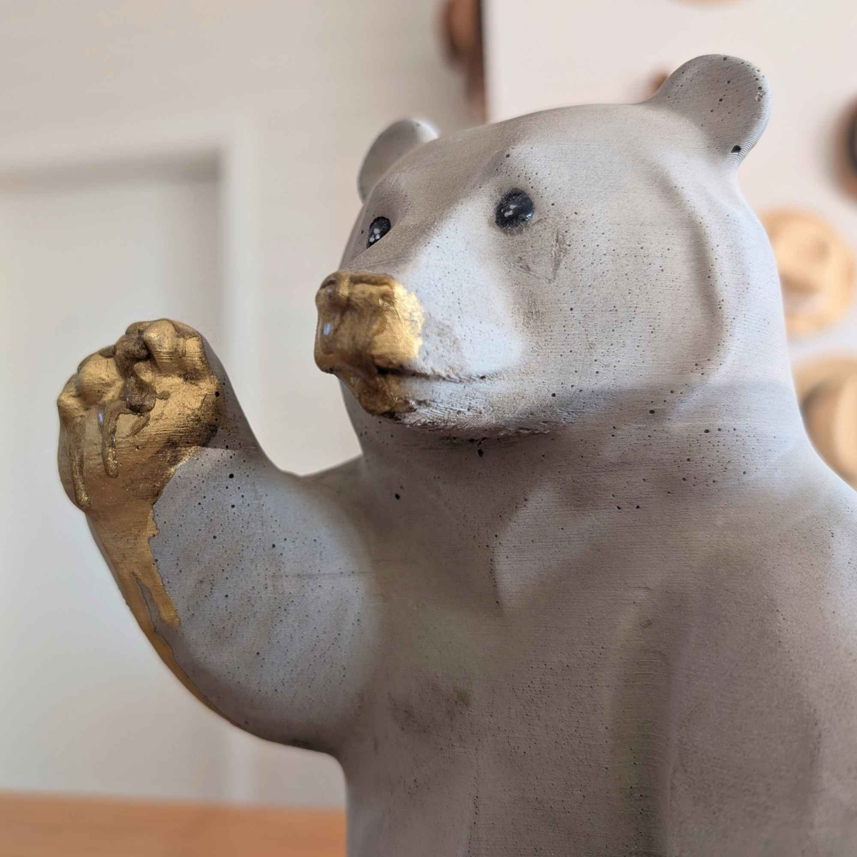 Close-up of honey bear face and raised gold paw