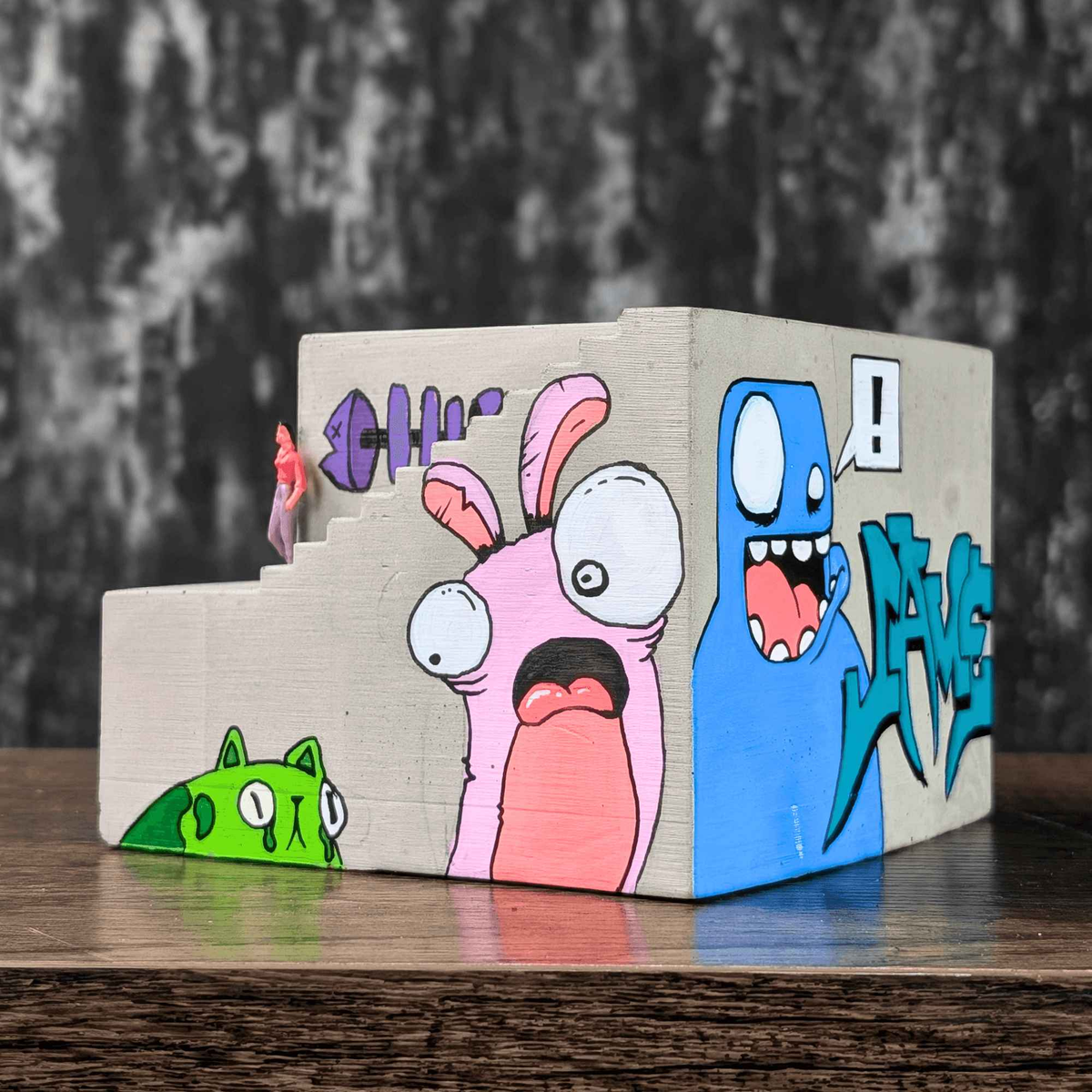 Rear three-quarter view showing cartoon faces around the graffiti planter