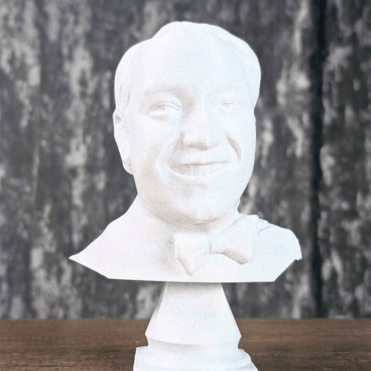 Front view of a white bow-tie portrait bust on a pedestal