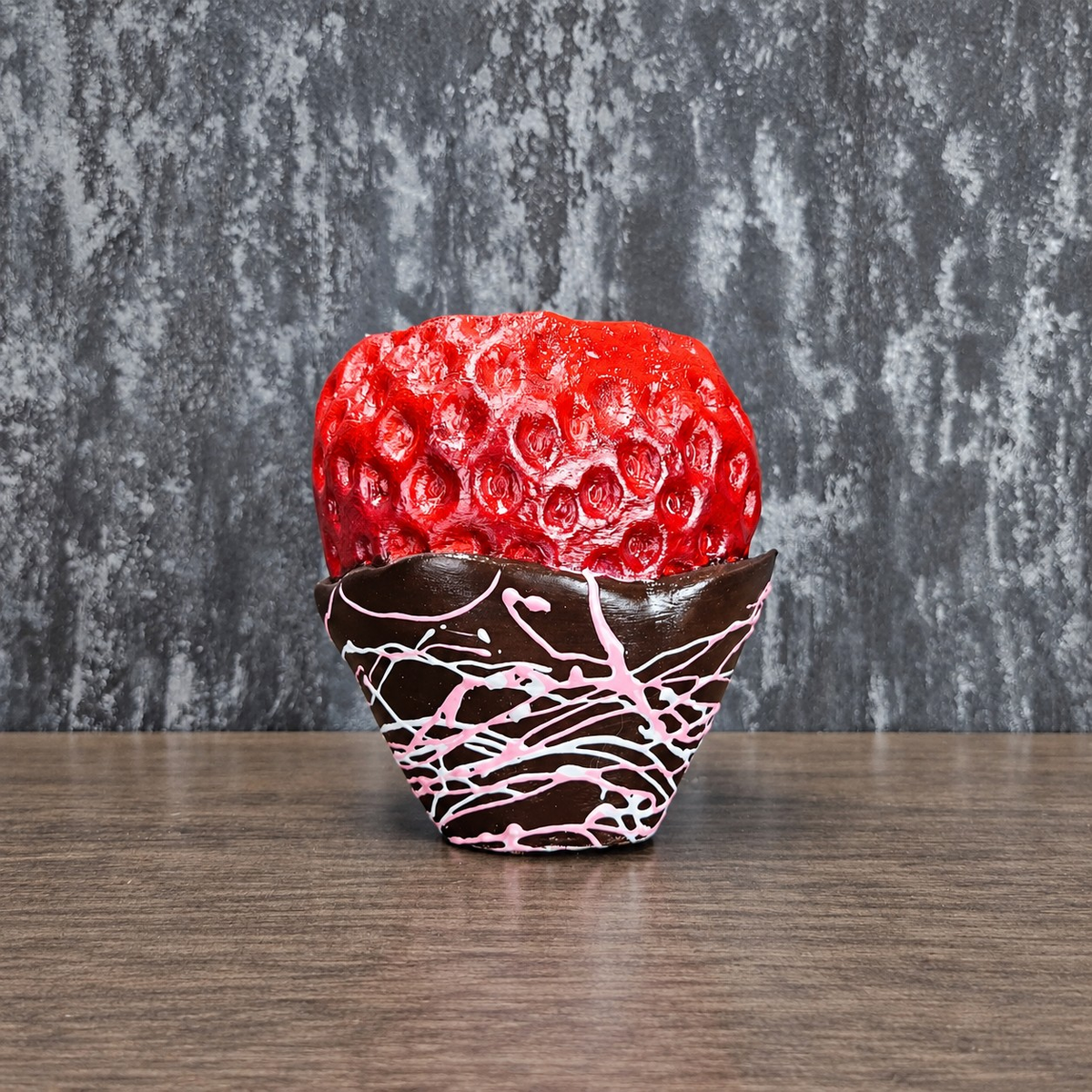 Unplanted chocolate-dipped strawberry planter with pink drizzle shown front-on