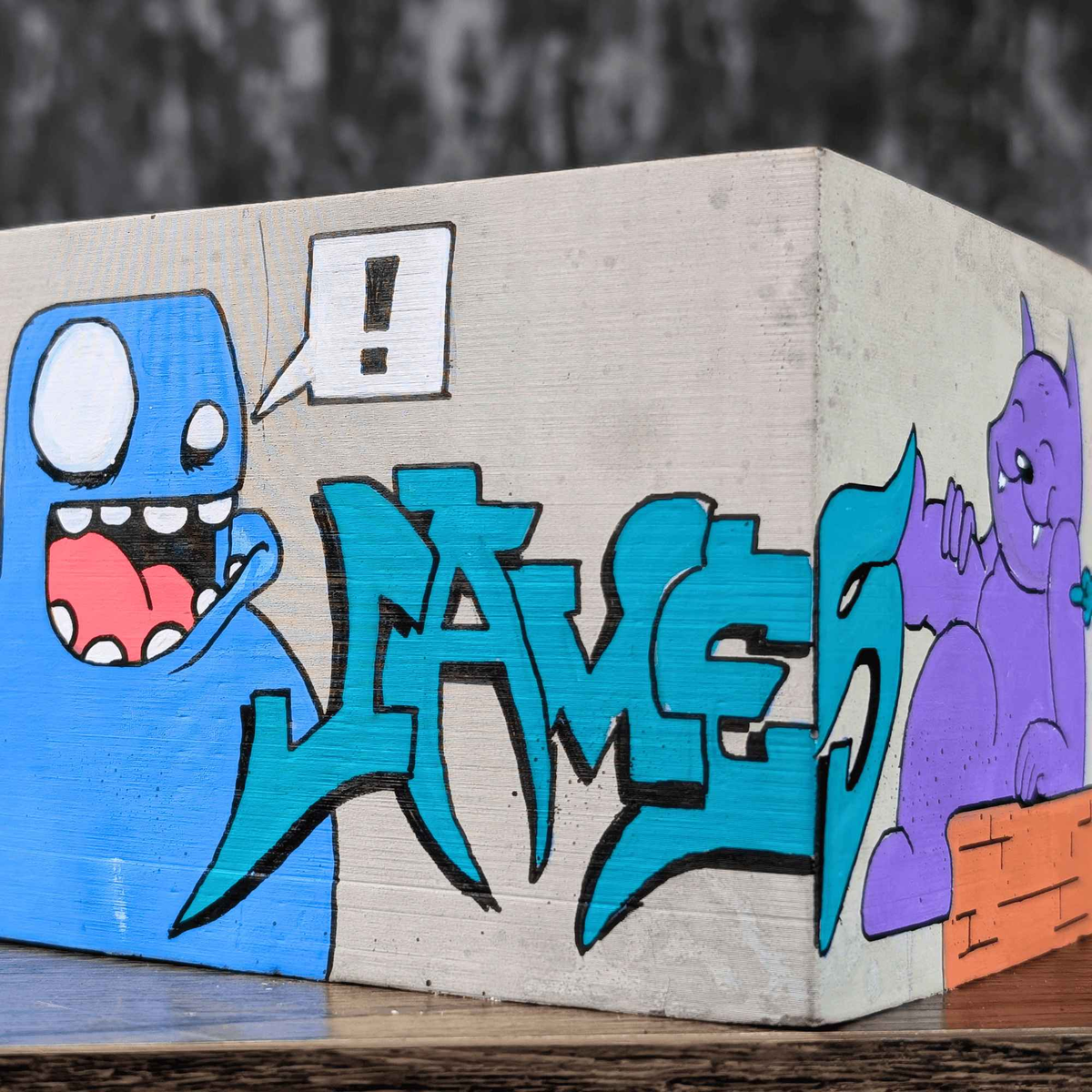 Side view of blue graffiti lettering and cartoon characters on the planter