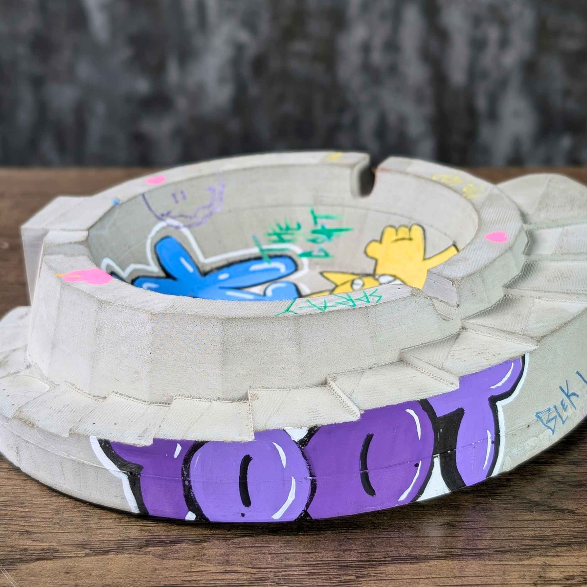 Custom graffiti concrete ashtray angled side view