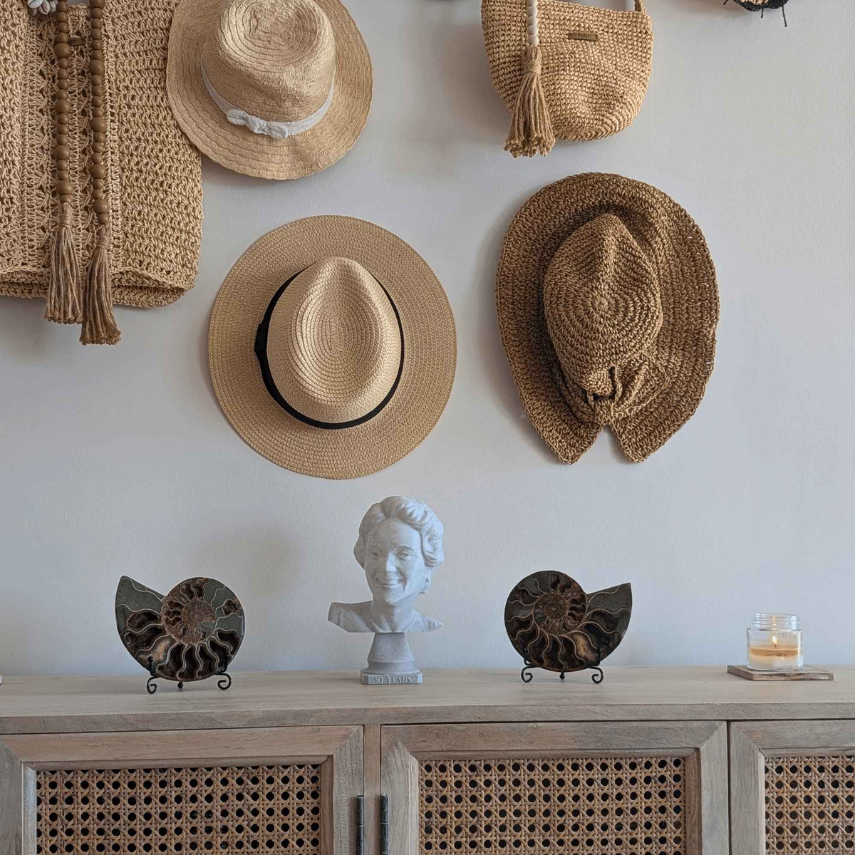 Small custom portrait bust displayed on a sideboard beneath a collection of hats