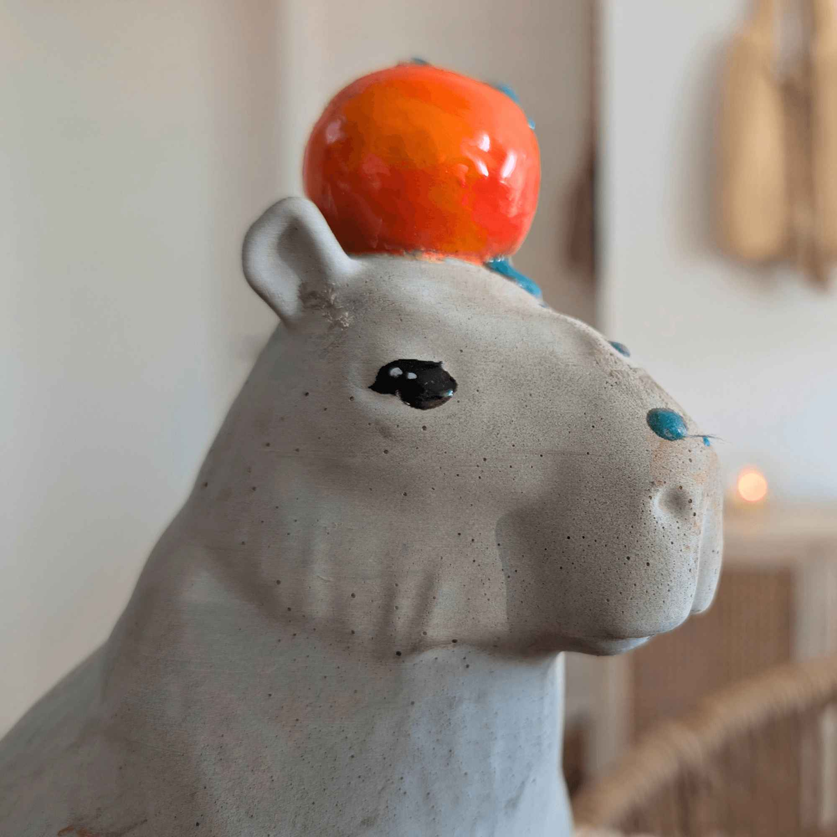 Close-up of the cast stone capybara's face and orange