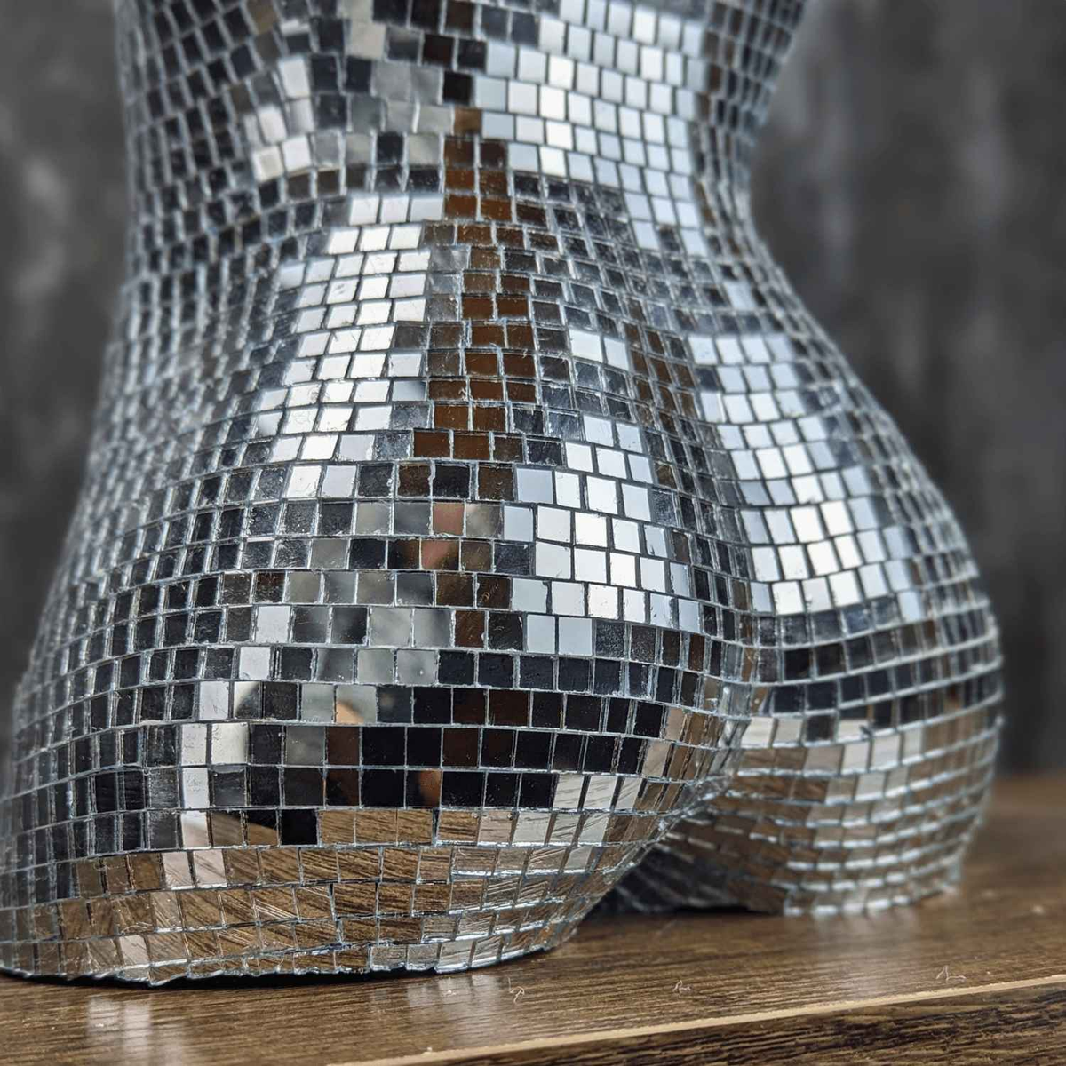 Close-up of mirror tiles across the waist and hip of the torso planter