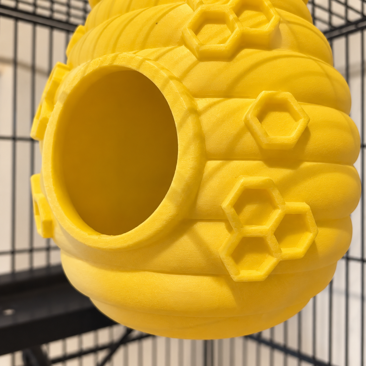 Close view of the yellow hive entrance rim, rounded bands and raised honeycomb shapes.