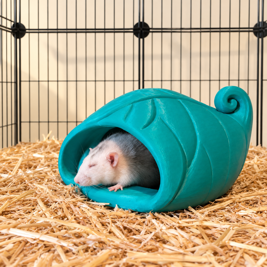 Pale rat resting with a paw on the opening of a teal-green curled-leaf floor hide on clean bedding.