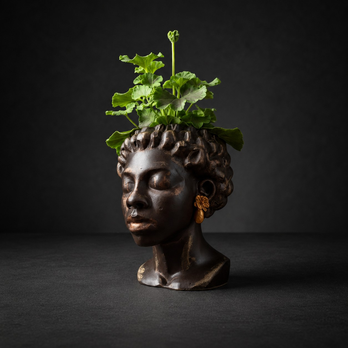 Three quarter view of cast stone bust planter with gold earrings