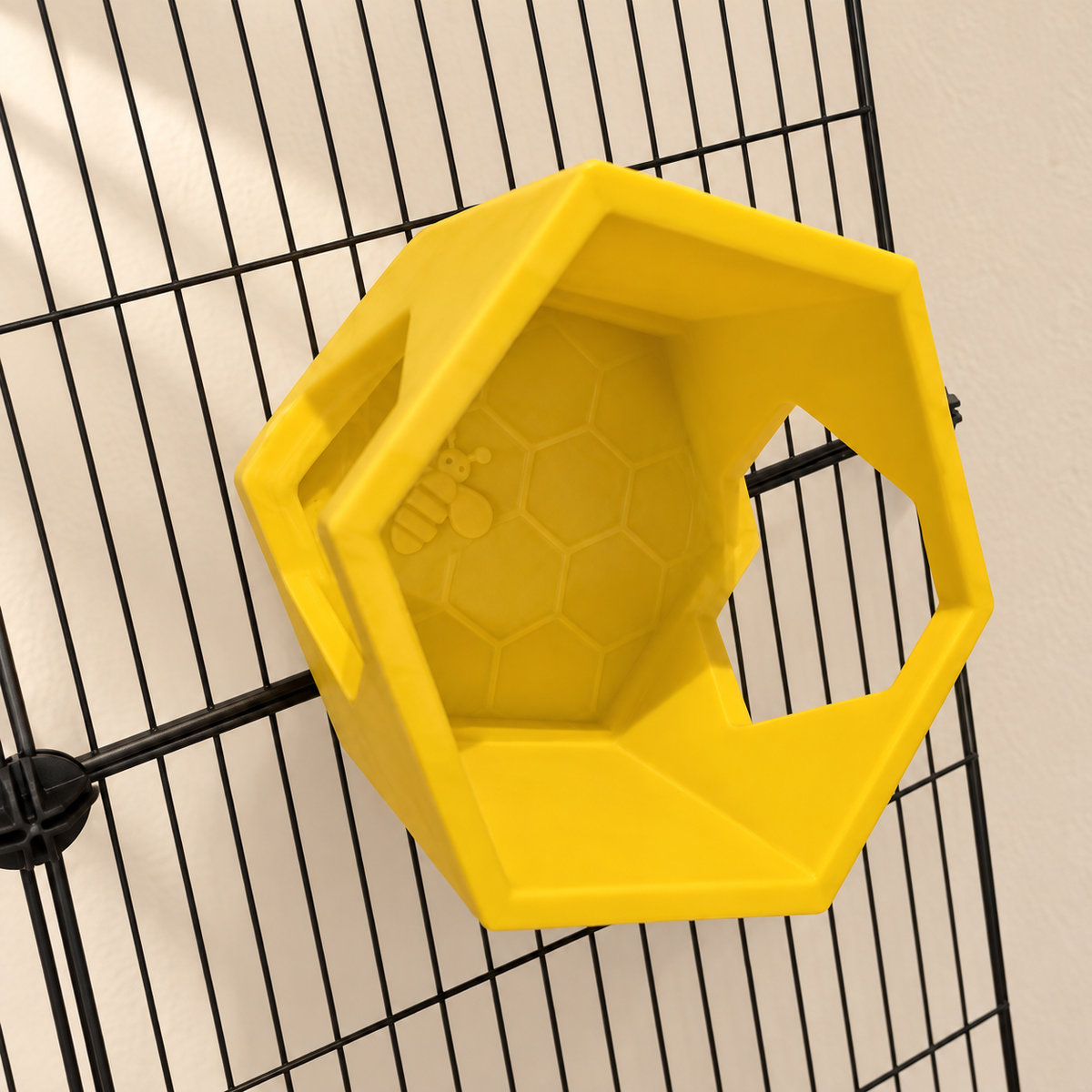 Angled view of one yellow honeycomb shelf showing its raised front rim, bee relief and side opening.