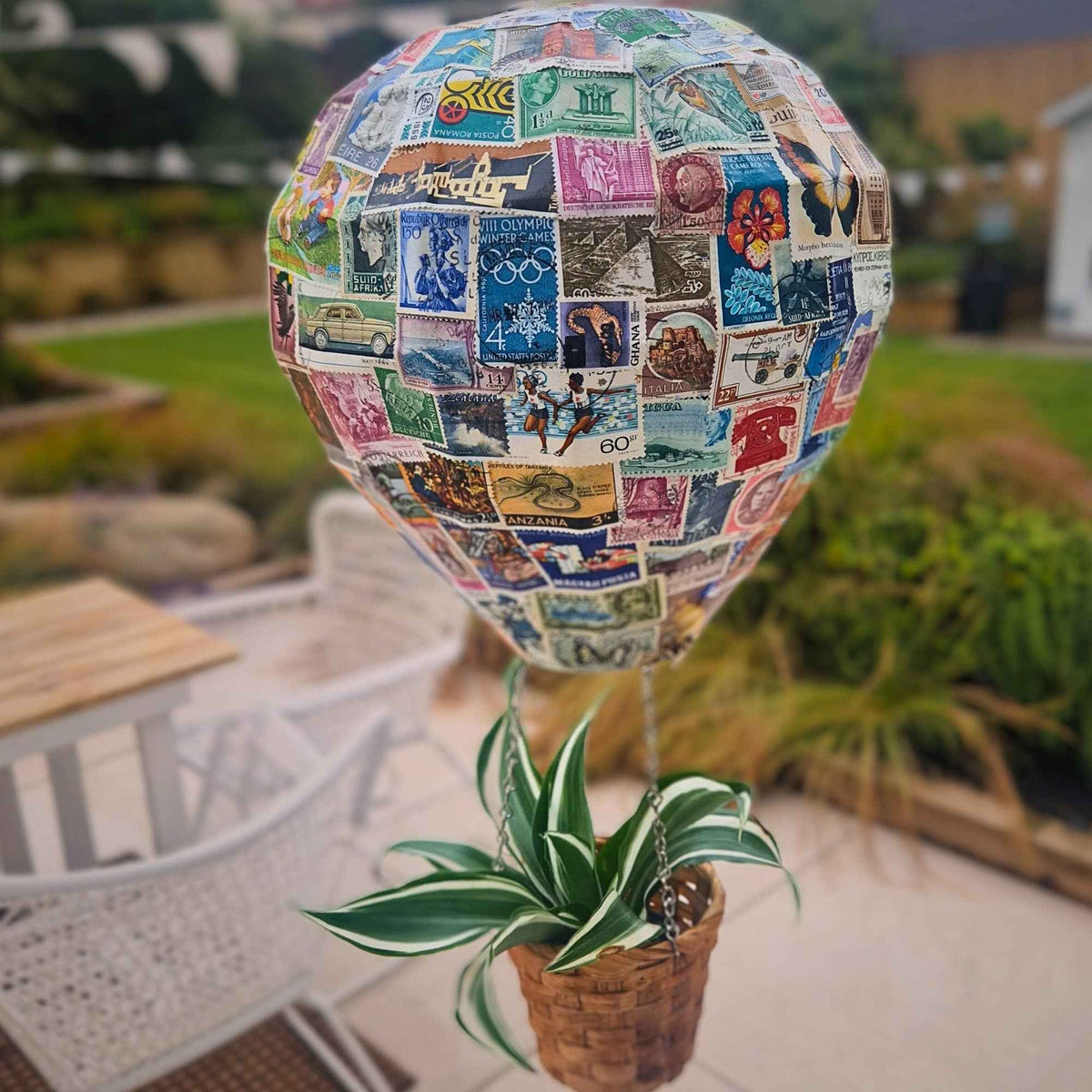 Safari Balloon Planter hanging outdoors above a garden table