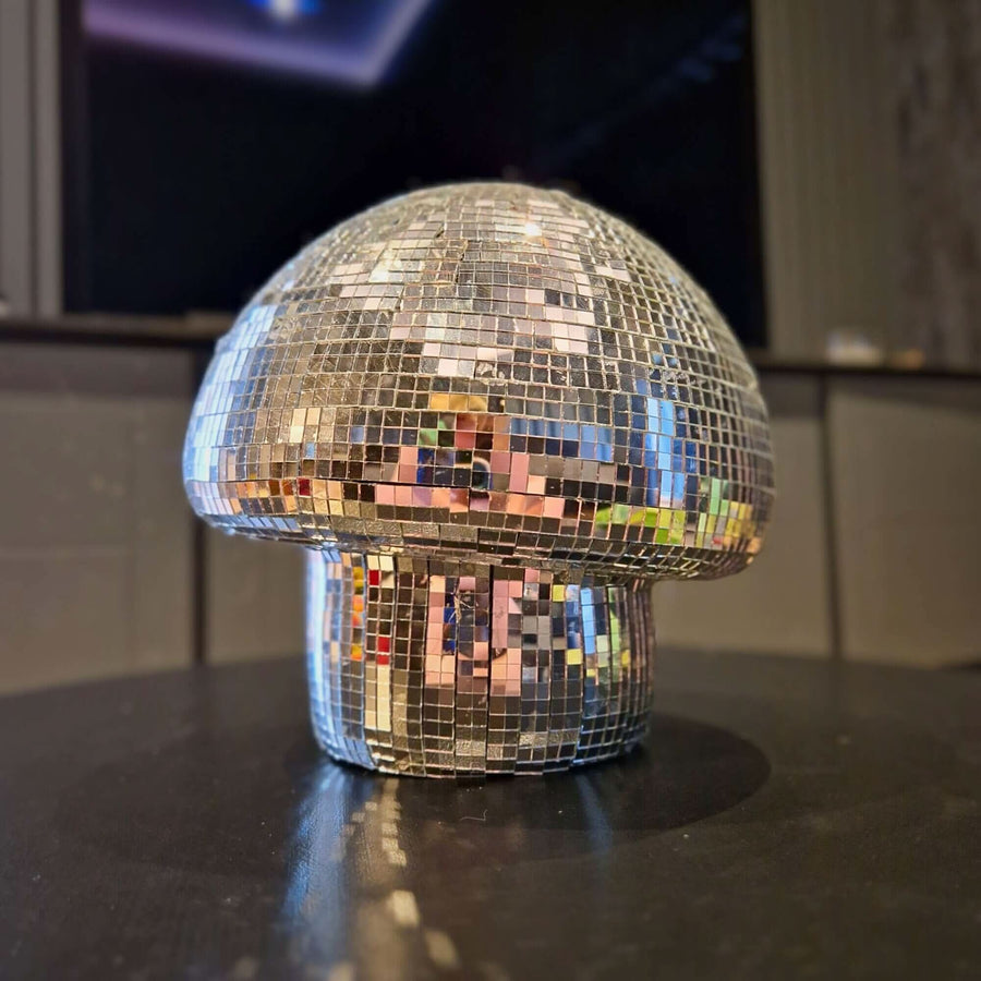 Large classic silver disco mushroom ornament on a dark tabletop