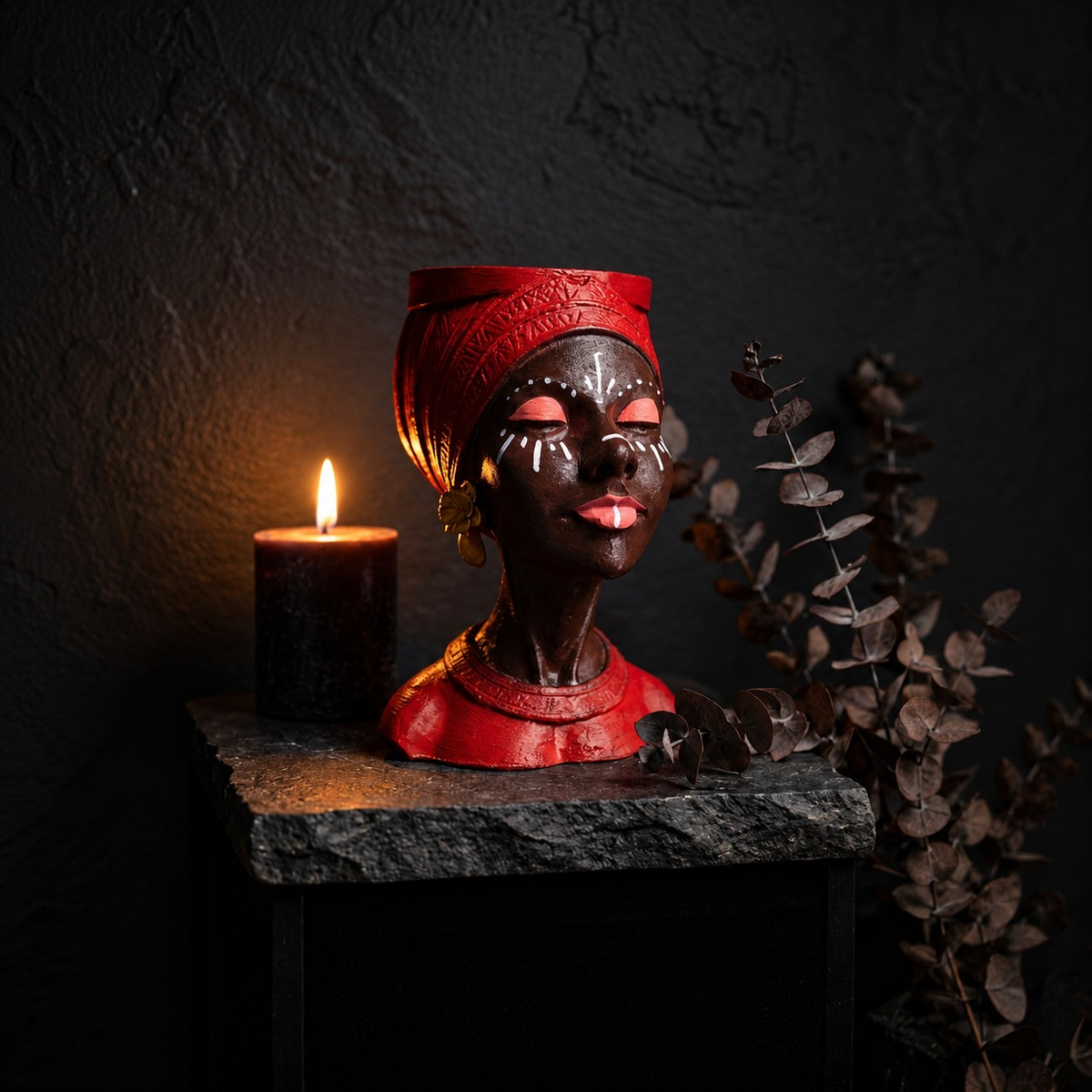 Unplanted red Afro woman head planter styled beside a lit candle