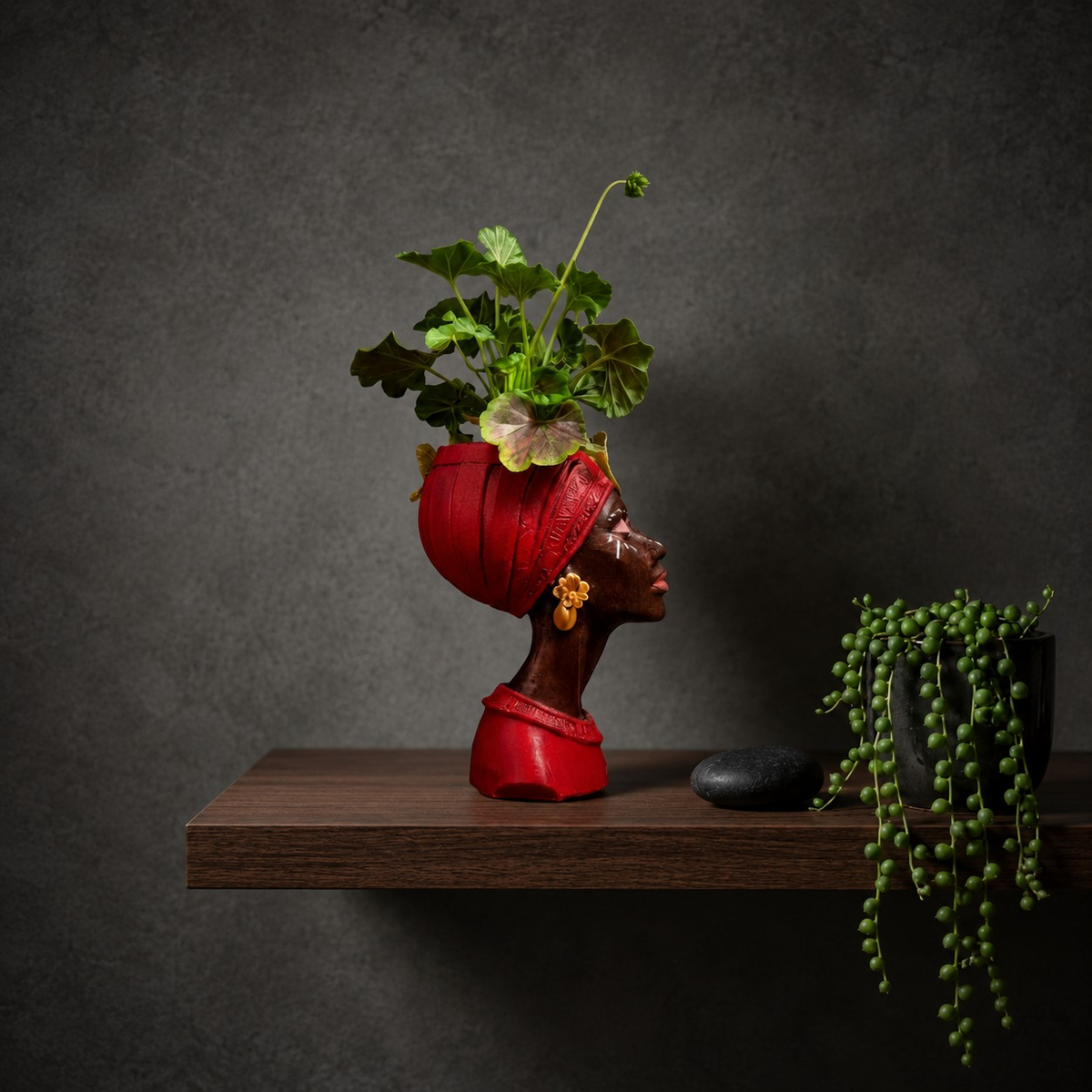Red Afro woman head planter in side profile on a wooden shelf
