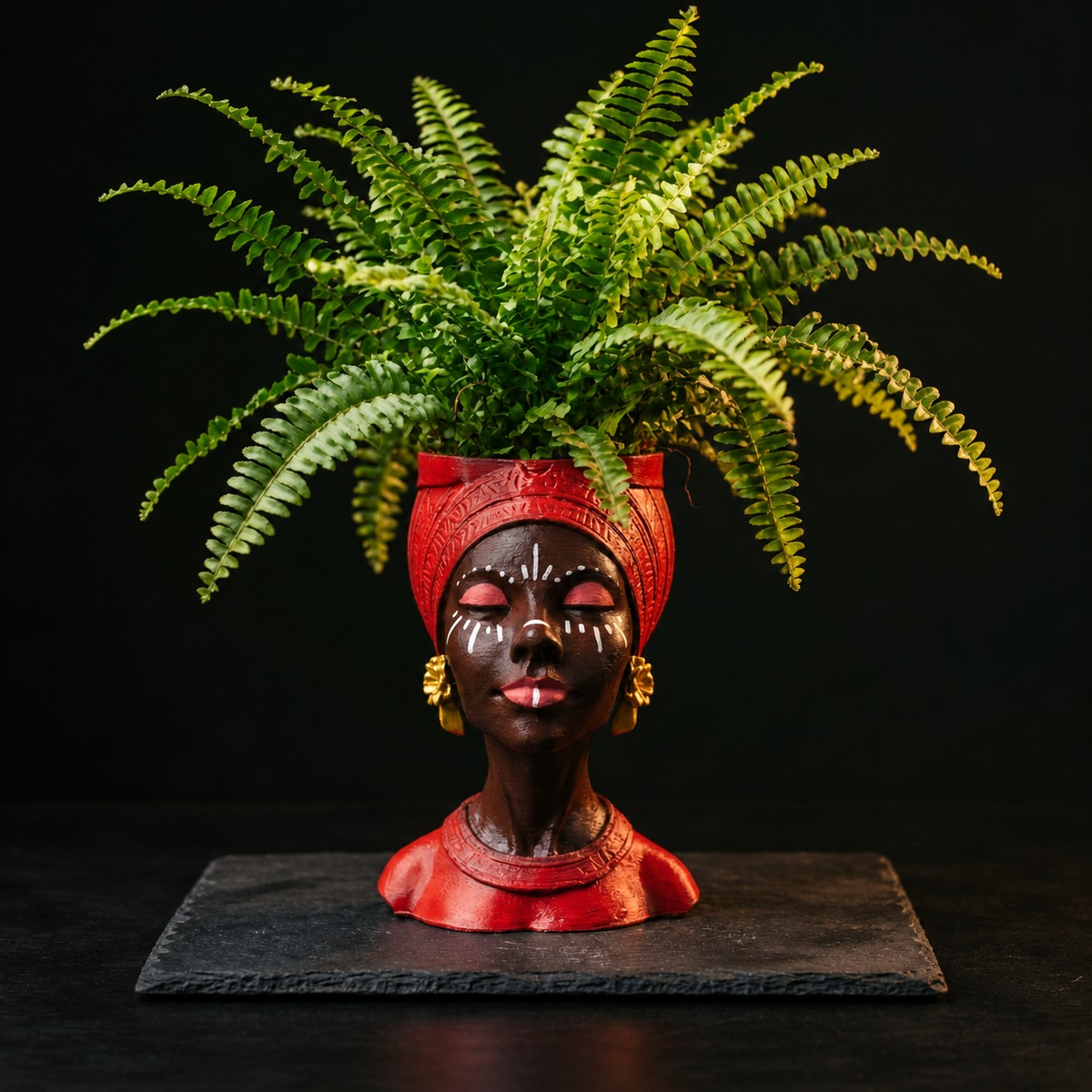 Red Afro woman head planter filled with a large green fern