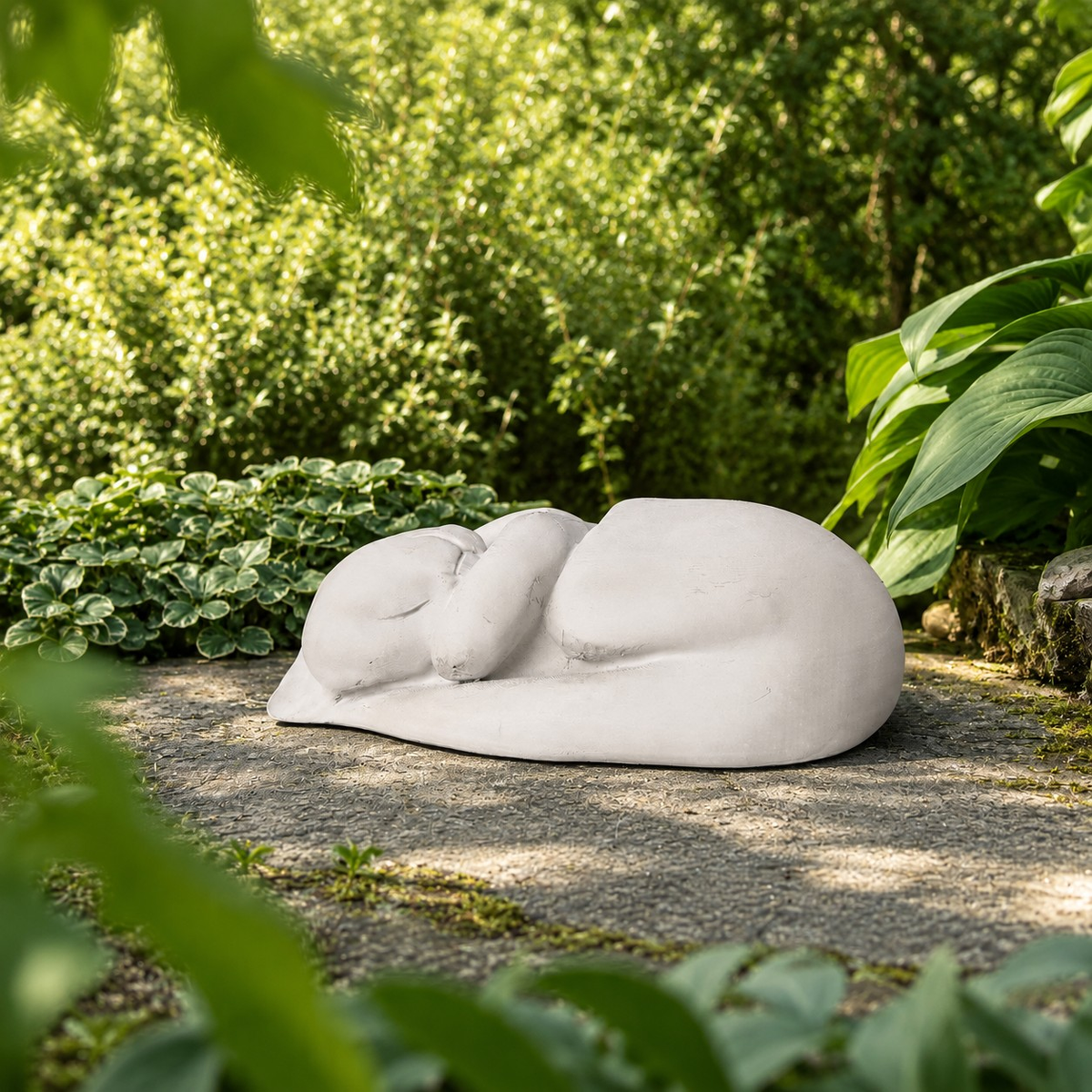 Sleeping Cat Garden Statue in a shaded garden setting