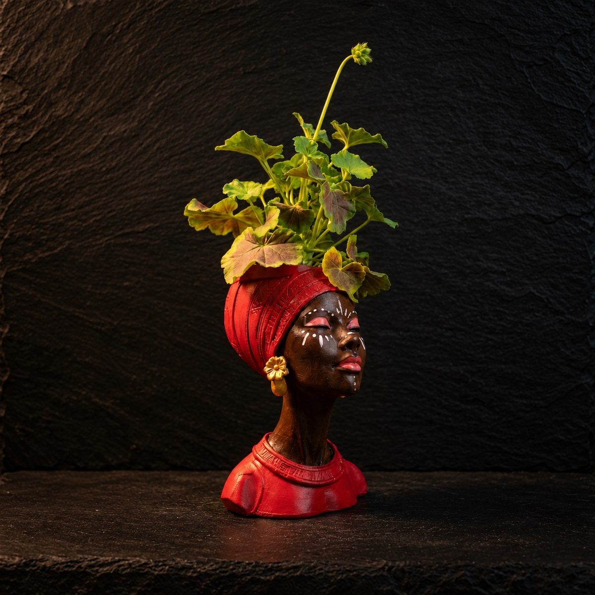 Red Afro woman head planter with gold earrings and pink geraniums